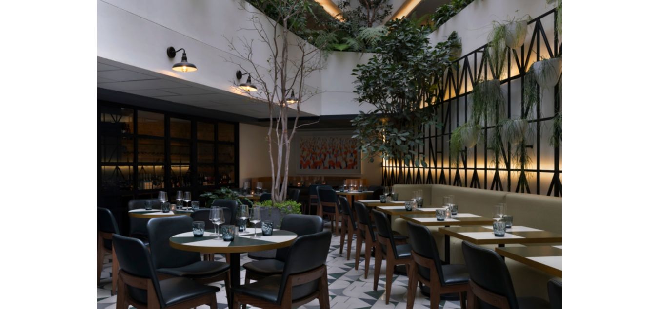 餐厅用餐区墙壁饰有大胆鲜明的植物装饰和壁画，营造引人入胜的氛围