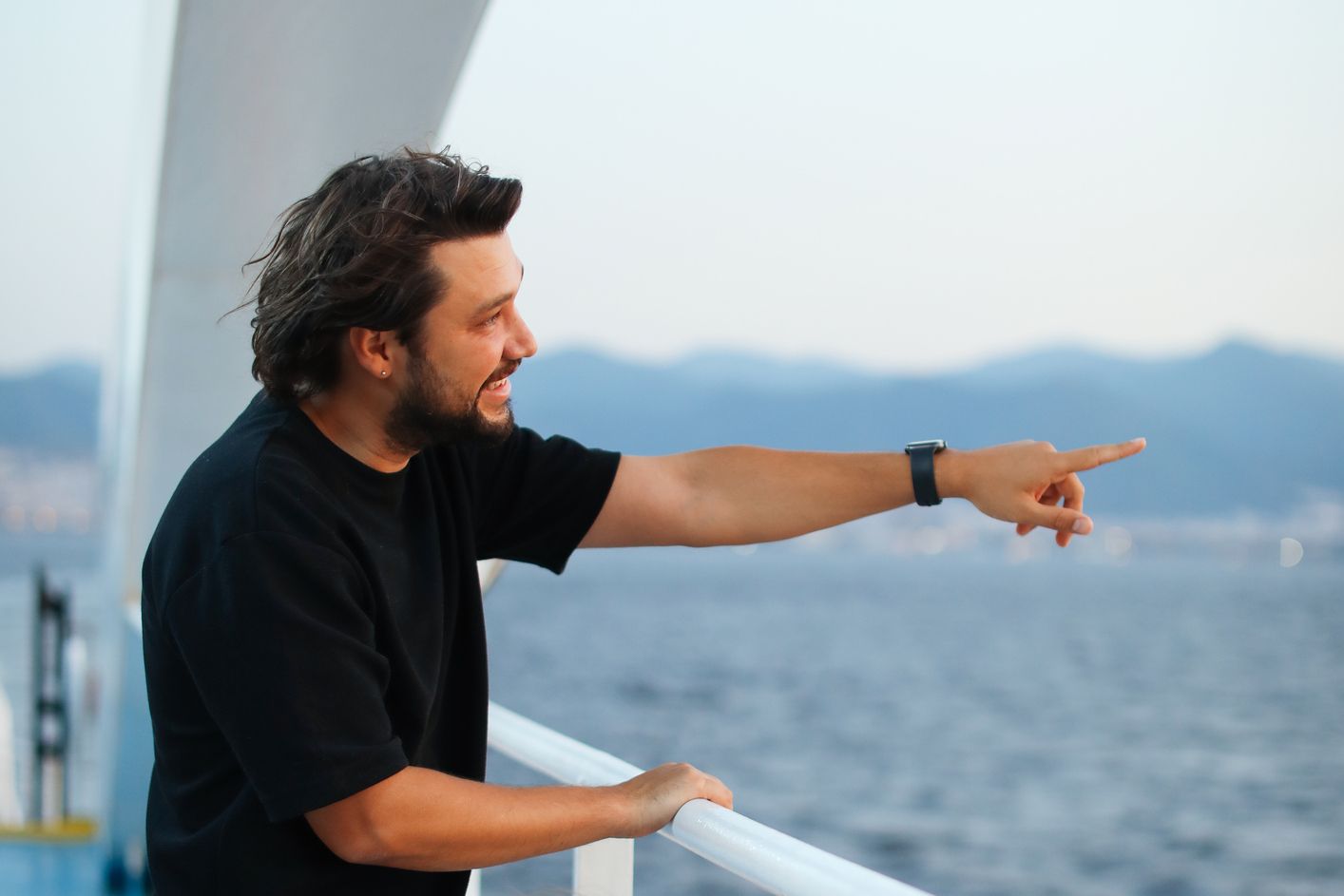 Man on a boat pointing at ocean