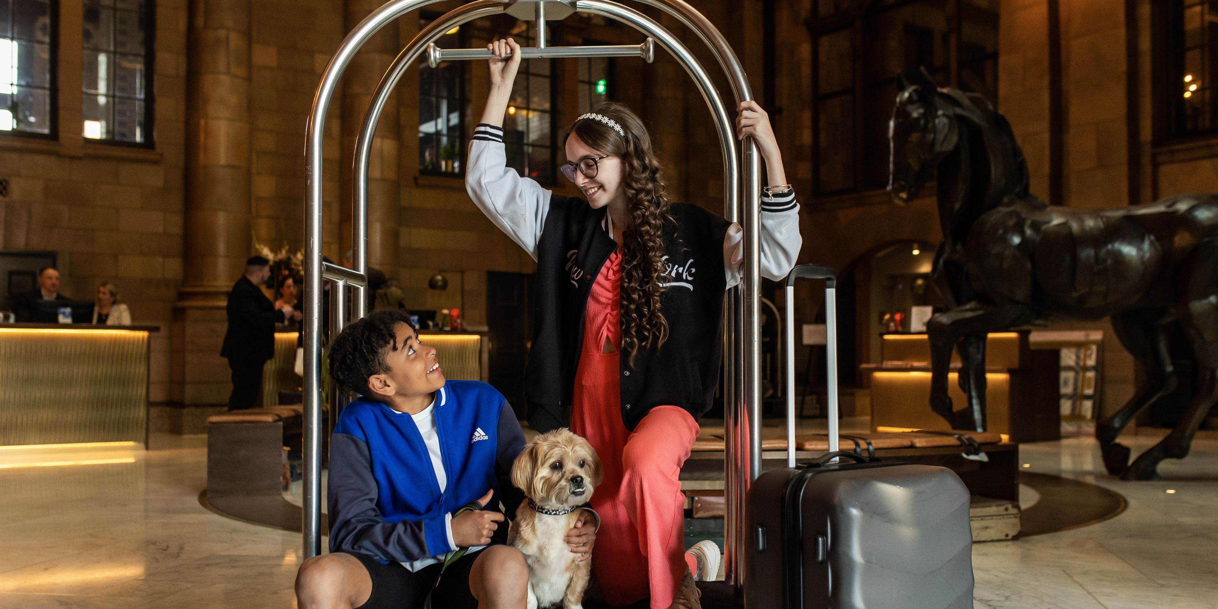 Kids on a luggage cart in hotel lobby
