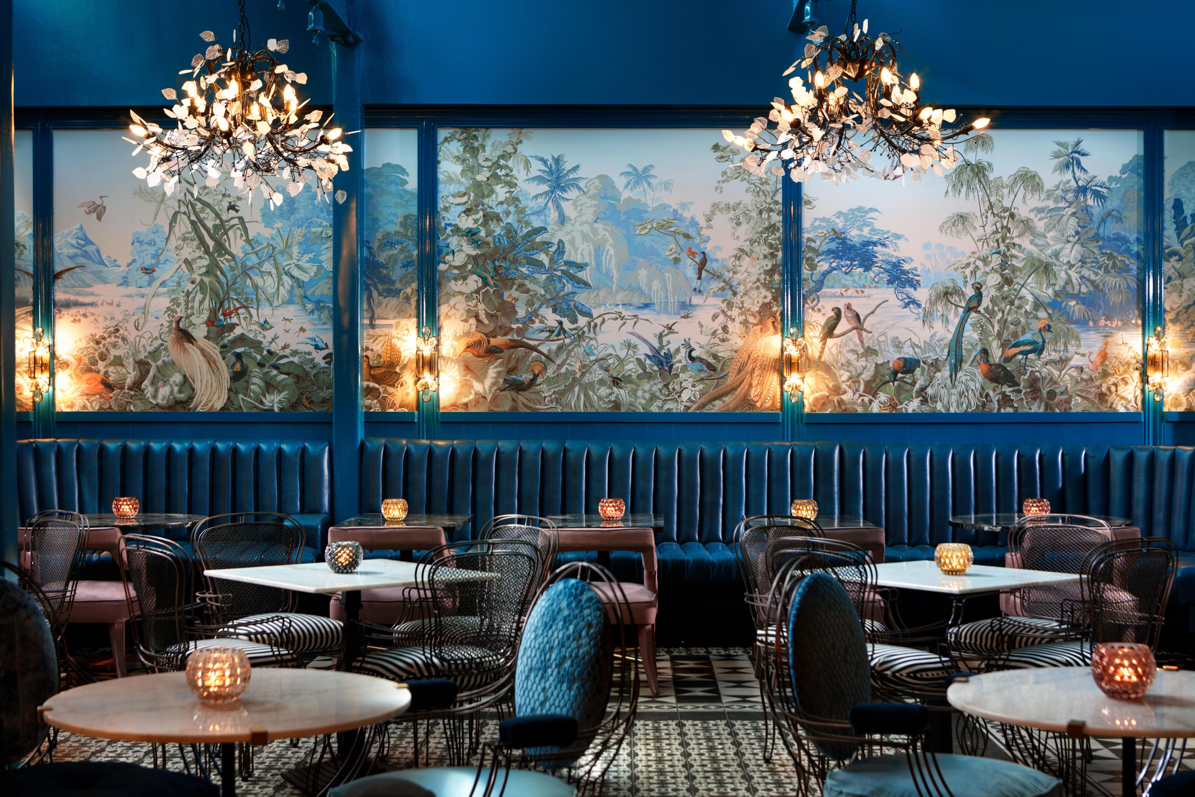 孔雀风格的餐厅，配有蓝色豪华座椅和多彩壁画