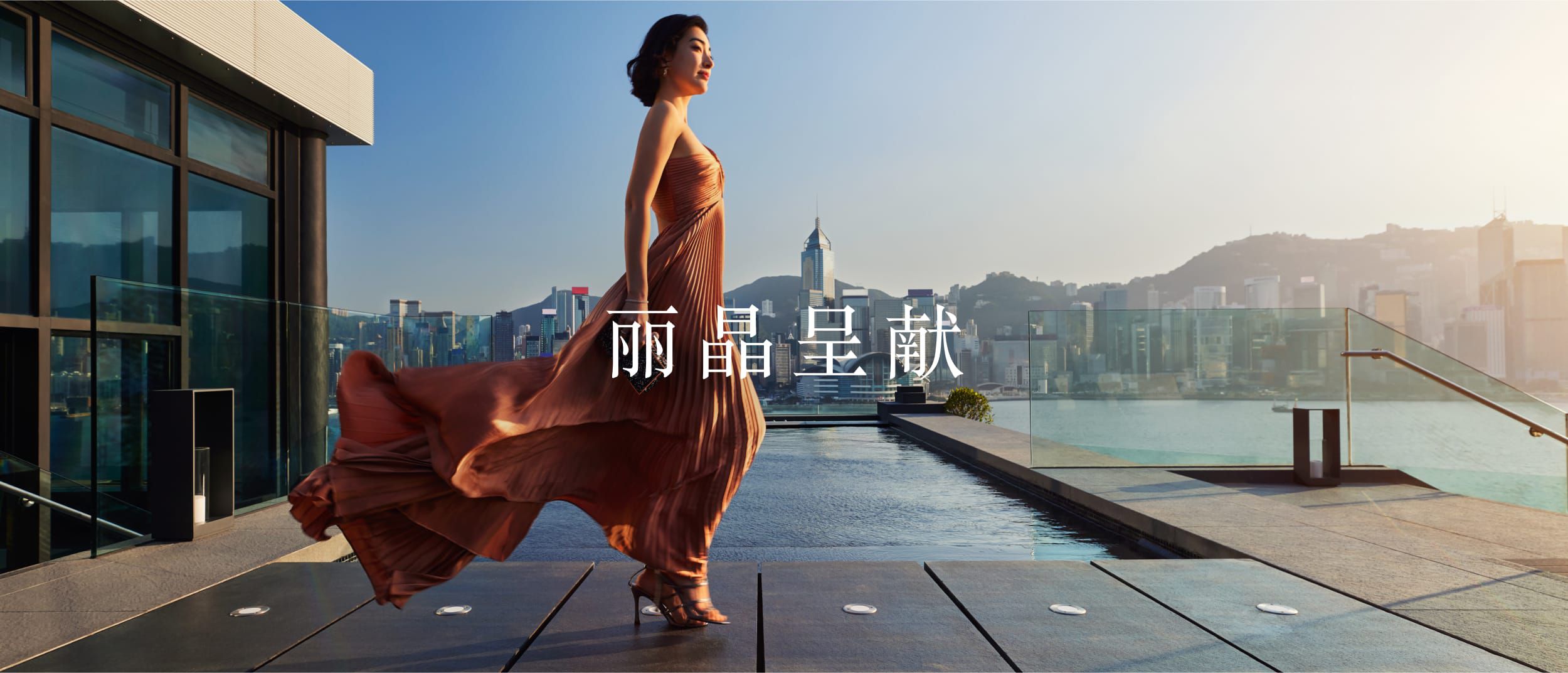 woman in formal dress standing on a balcony with wind blowing 