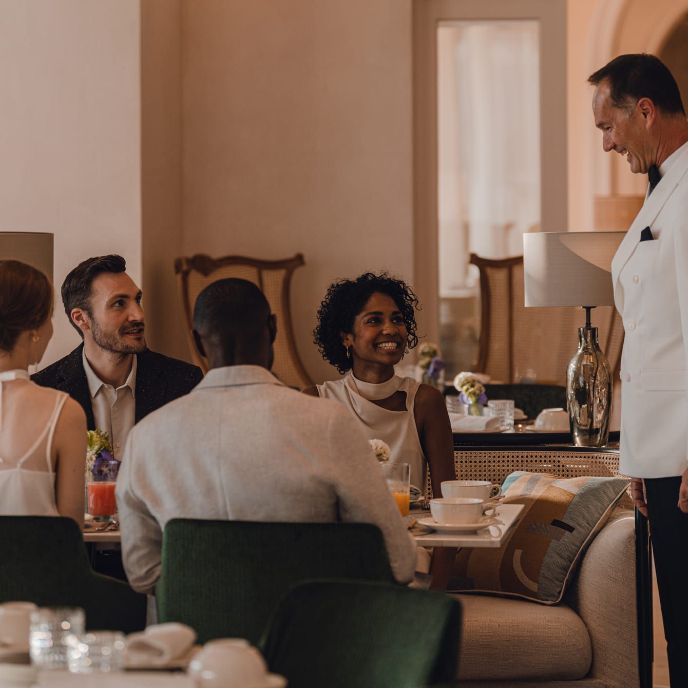 A charming host awaiting a table of smiling guests.