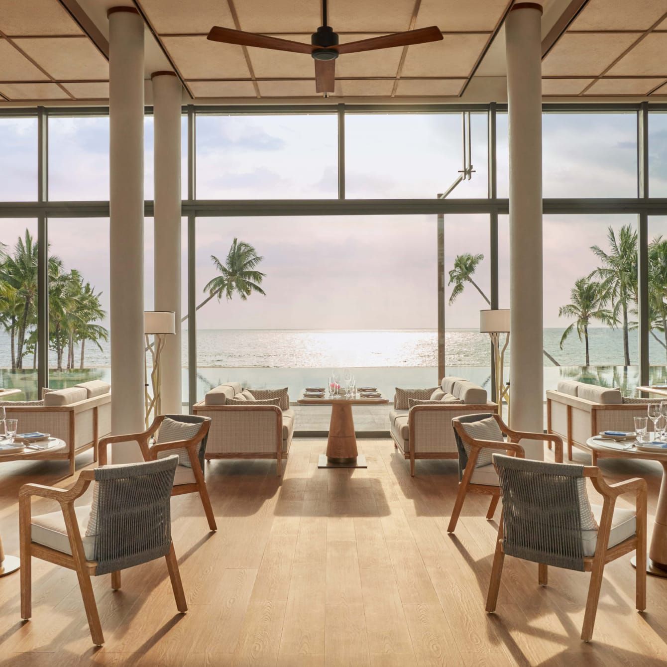 A wide-open dining space overlooking a sunlit ocean view.