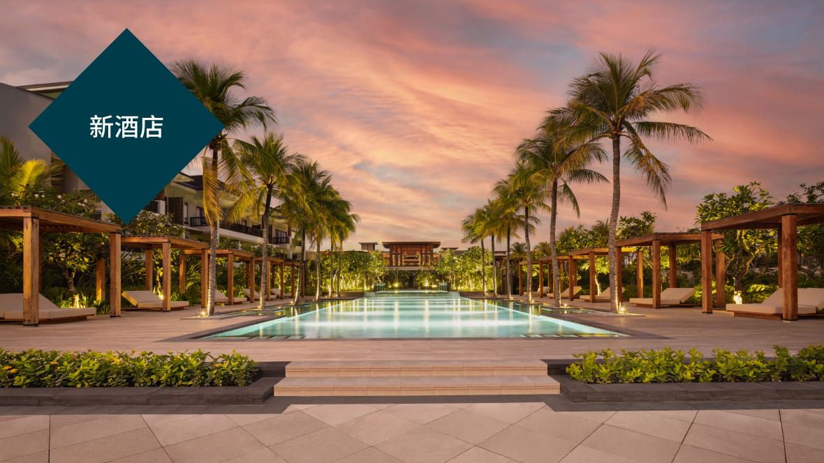 日落黄昏时分，被棕榈树环绕的新开业巴厘岛长谷丽晶酒店泳池