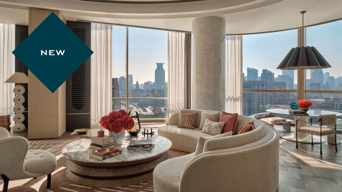 suite with curved sofa, dining table and stunning city views