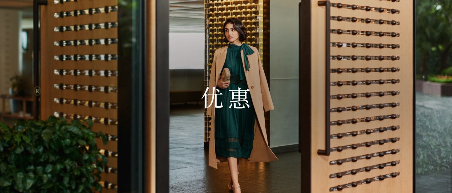 woman in a dress walking through doors into a lobby