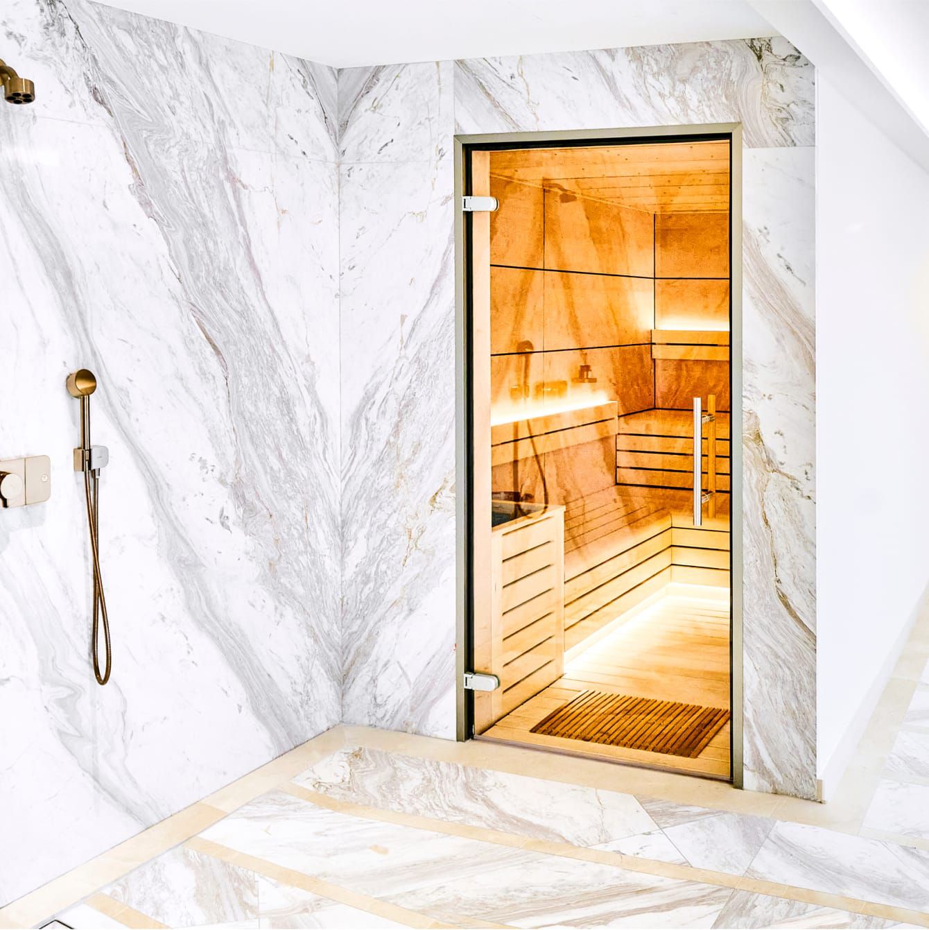 A spacious marble hydrotherapy shower and steam area.