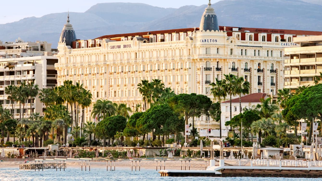 Palm lined promenade with hotel behind and the sea in front