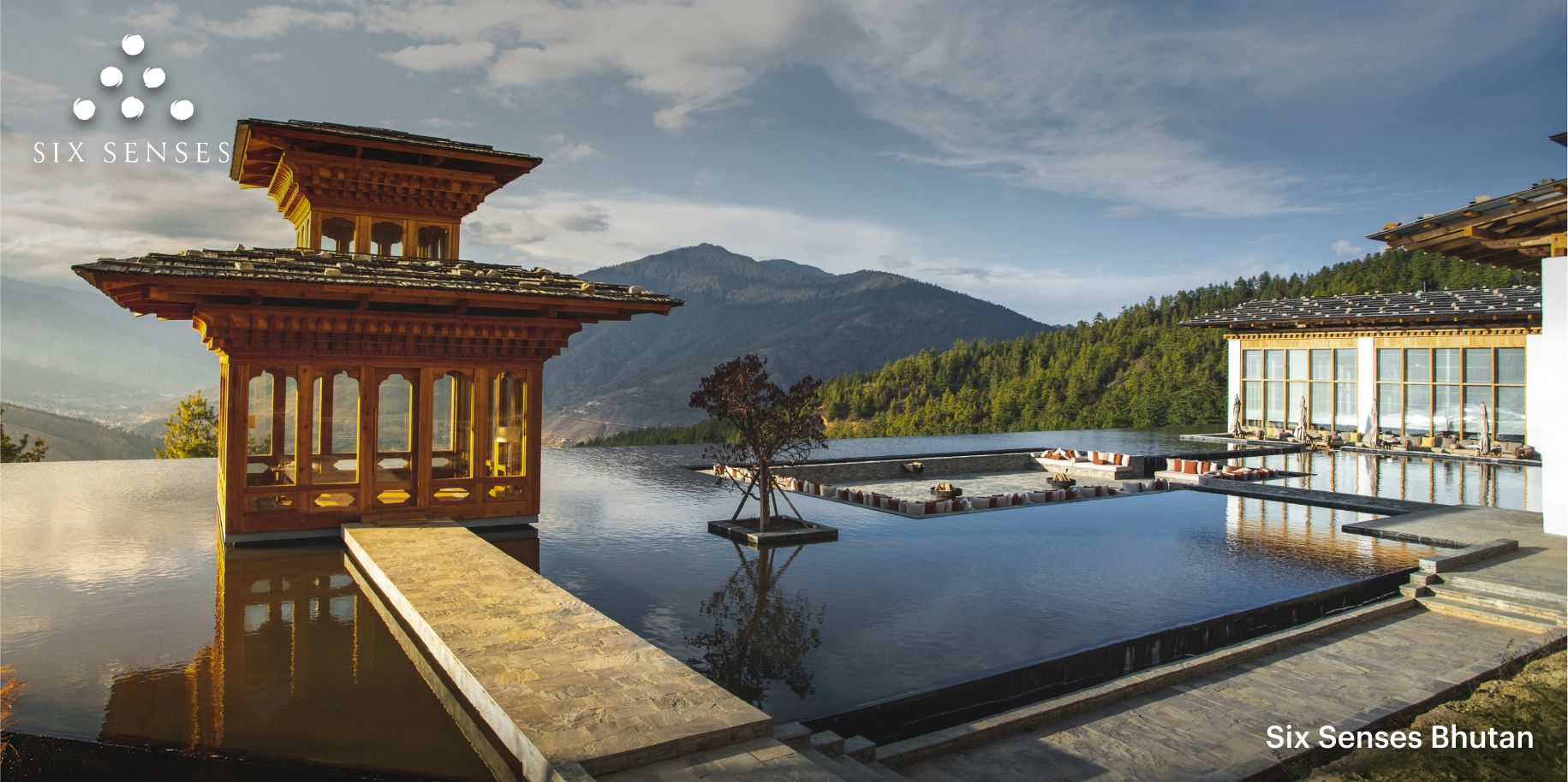 A serene view of the Six Senses Thimphu’s mesmerizing spa experience, featuring an infinity pool set against a backdrop of rolling green mountains.