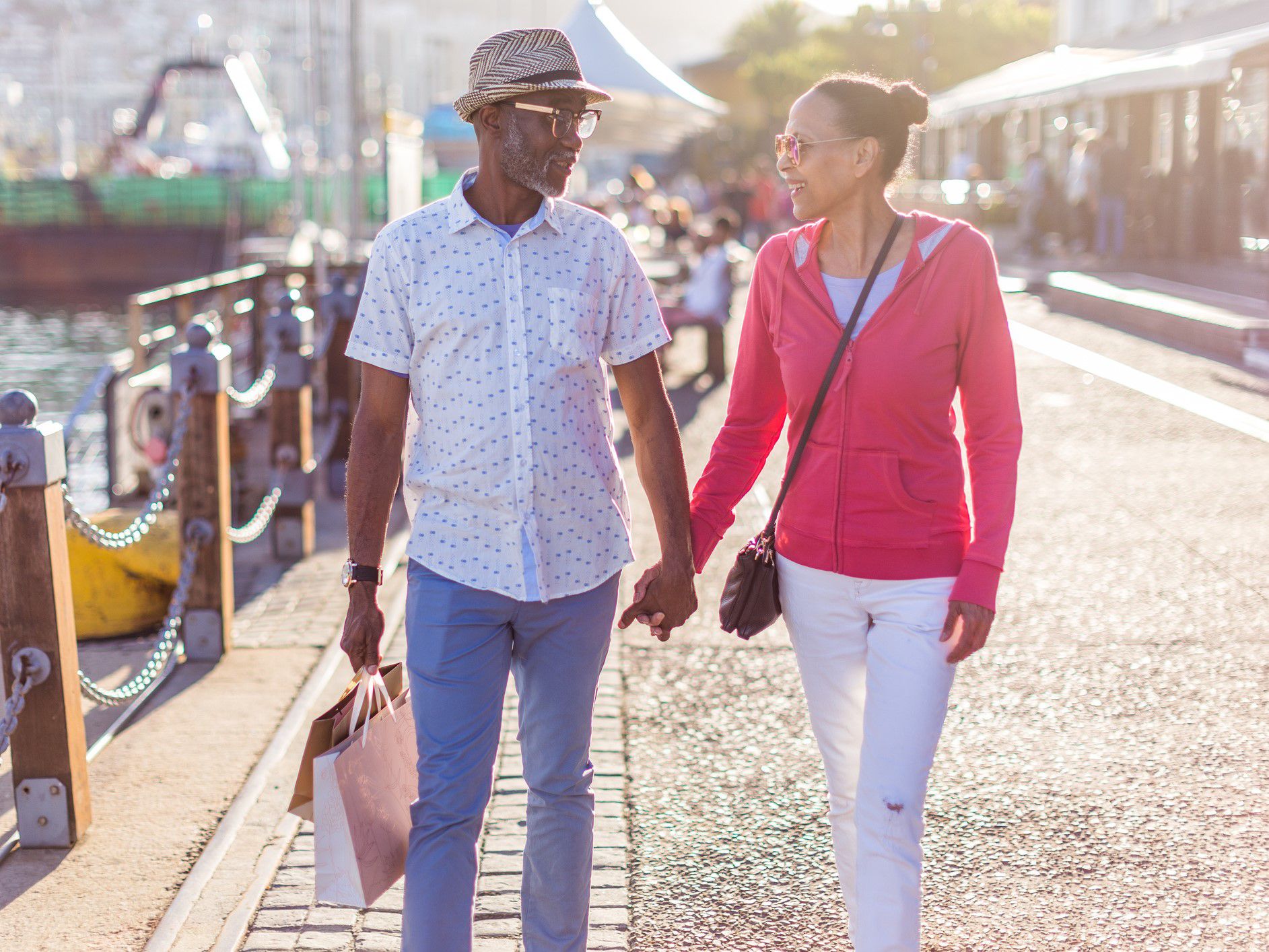 A couple with shopping bags walking near the water