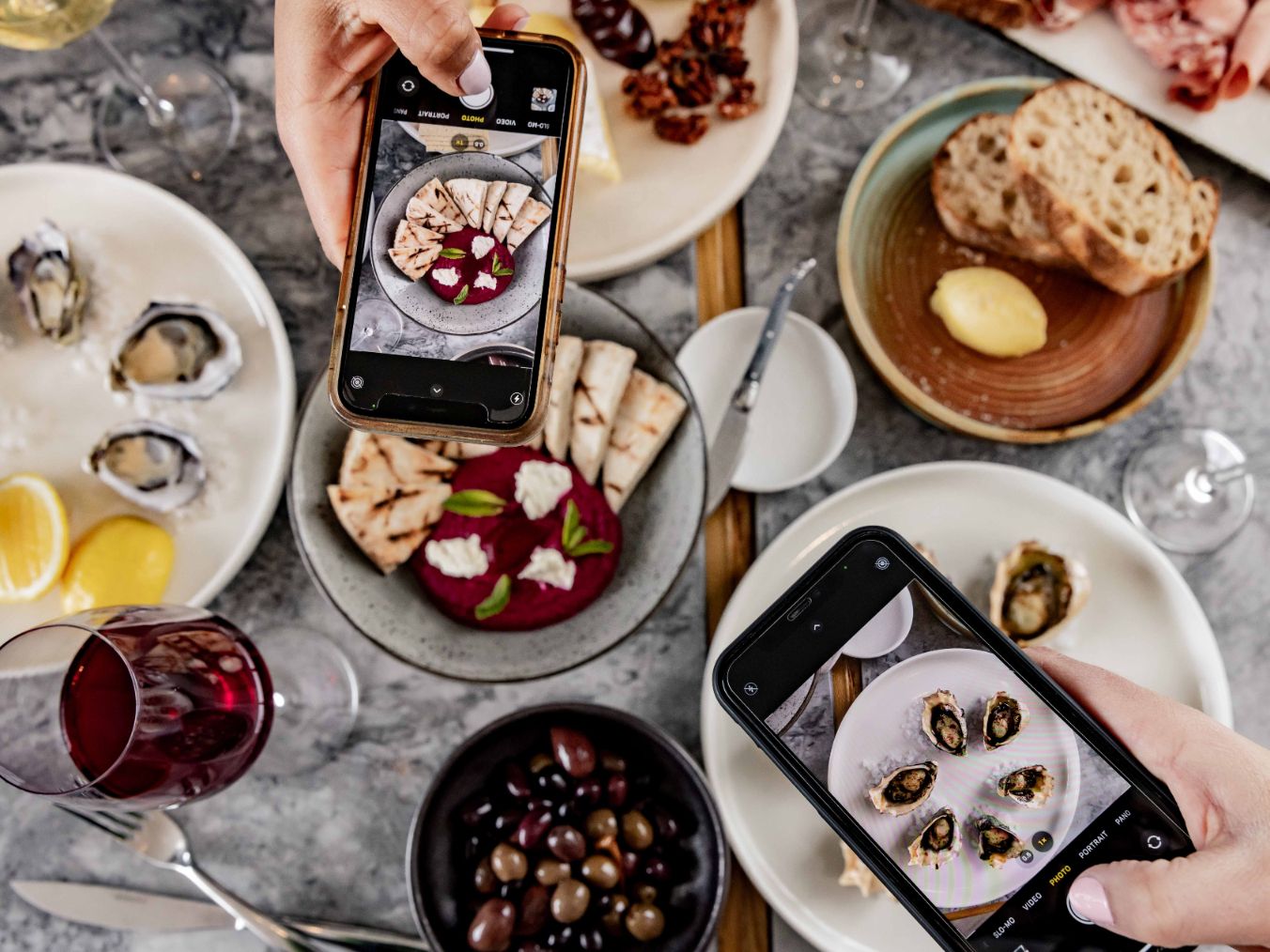 People taking photos of their food with their phones.