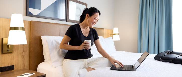 男宾客和狗位于 Staybridge 标志前