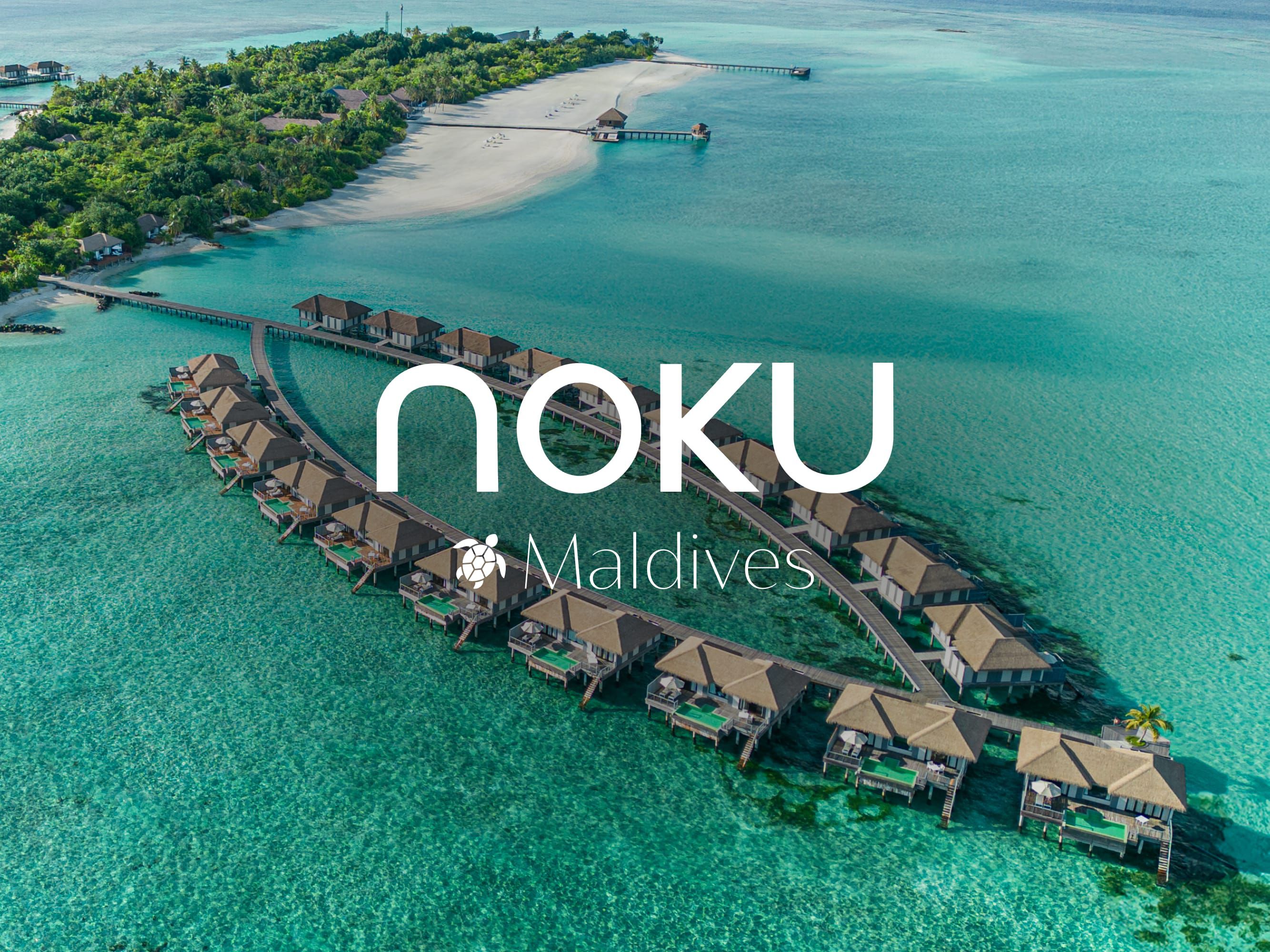 Luxurious view of the Noku Maldives huts over the glittering maldives water