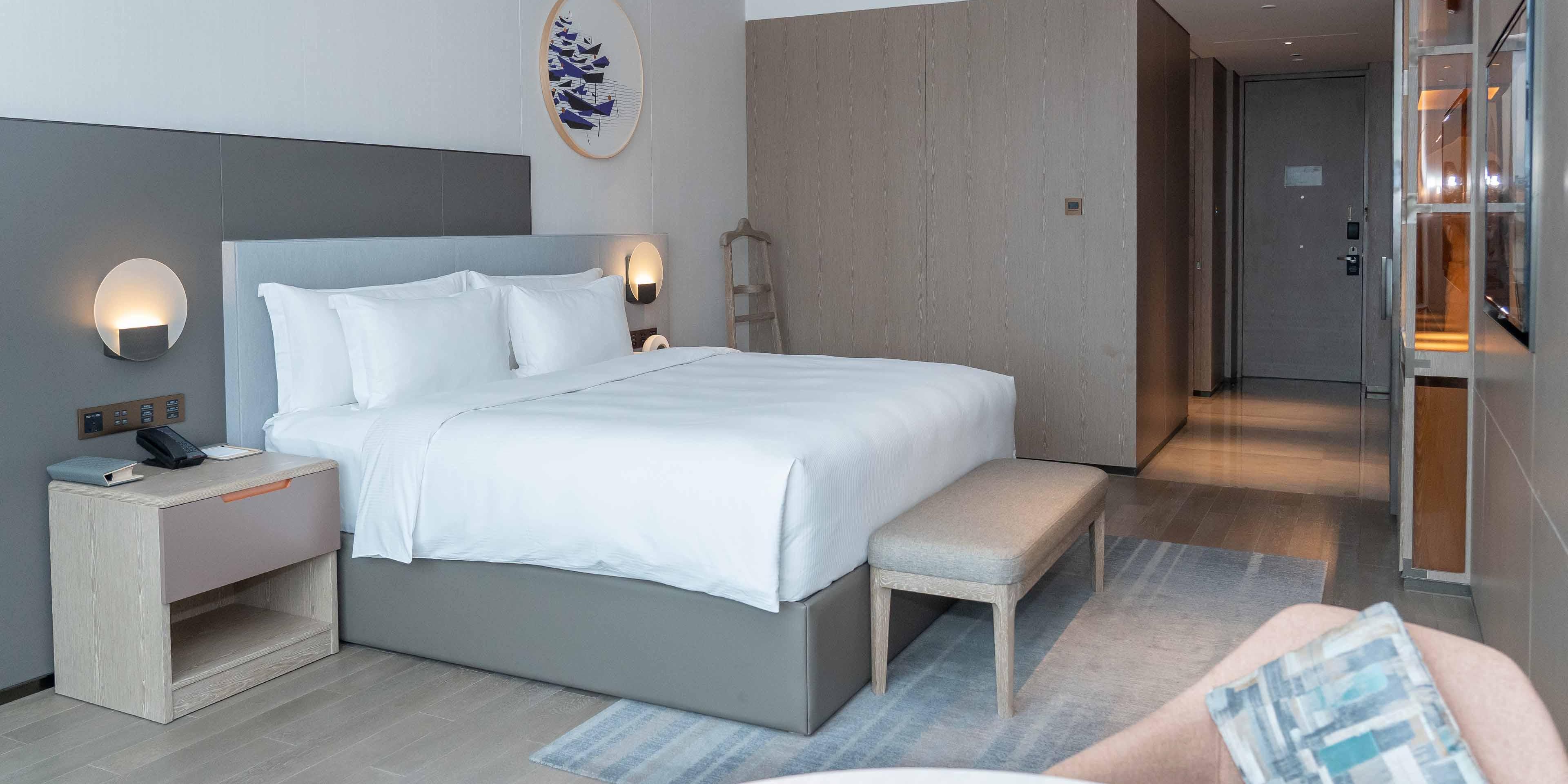 所有客房配备全景落地窗，自然光线充足，城市景观尽收眼底。房内选用高品质床垫与奢华洗浴用品，双人洗漱台及干湿分离卫浴设计兼顾便利与私密。细节处融入舒适与巧思，于都市中营造静谧安逸的旅居空间。