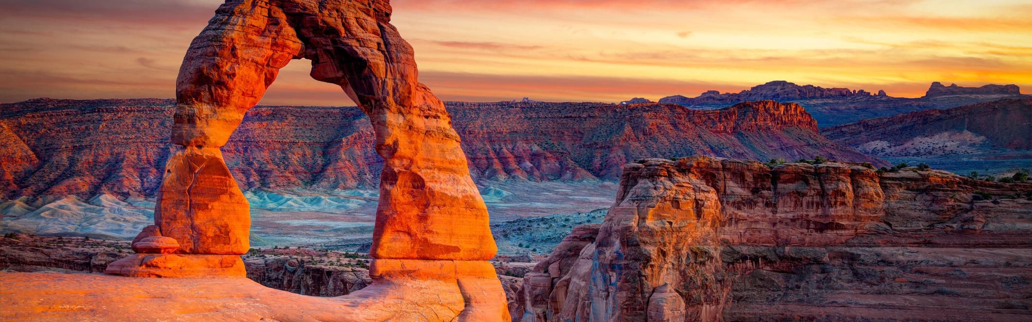 Watch the sunrise at Arches National Park.