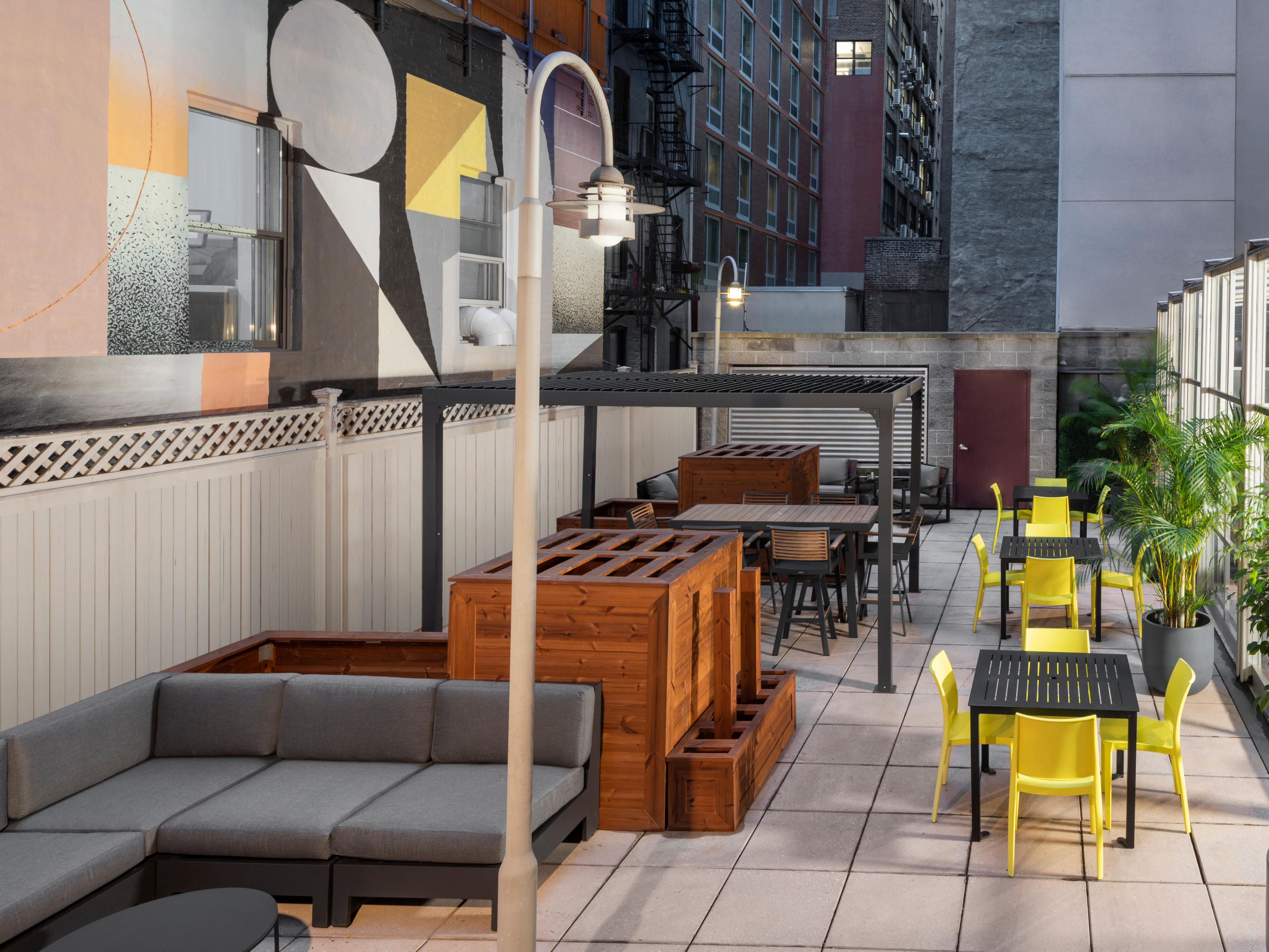 Vibrant mural art meets Manhattan views on our outdoor patio.