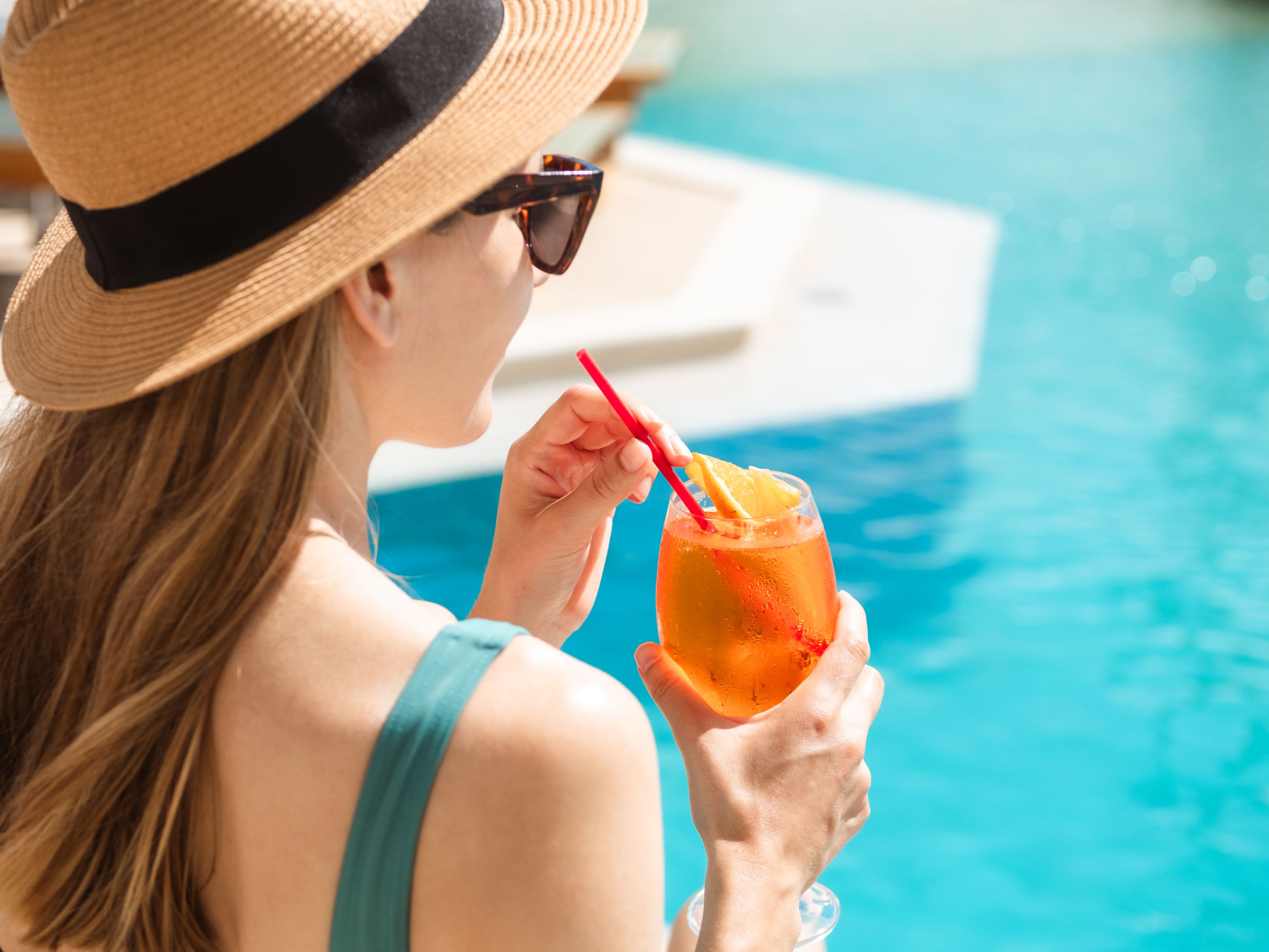 Woman with a cocktail by the pool